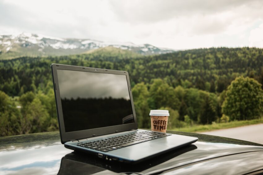compressed laptop takeaway coffee car s hood with beautiful natural scenery background