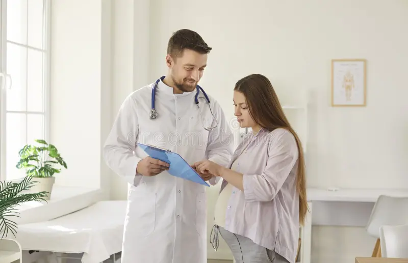 young pregnant women visiting male gynecologist doctor hospital medical clinic obstetrician doctor showing report file 460417218