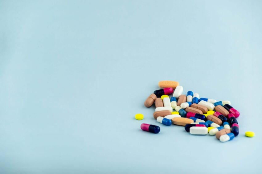 simple pile colorful pills medicines pills stacked blue background medical supplies min