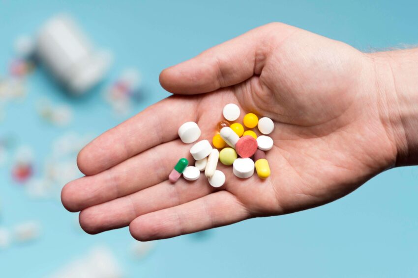 flat lay hand holding assortment pills 1