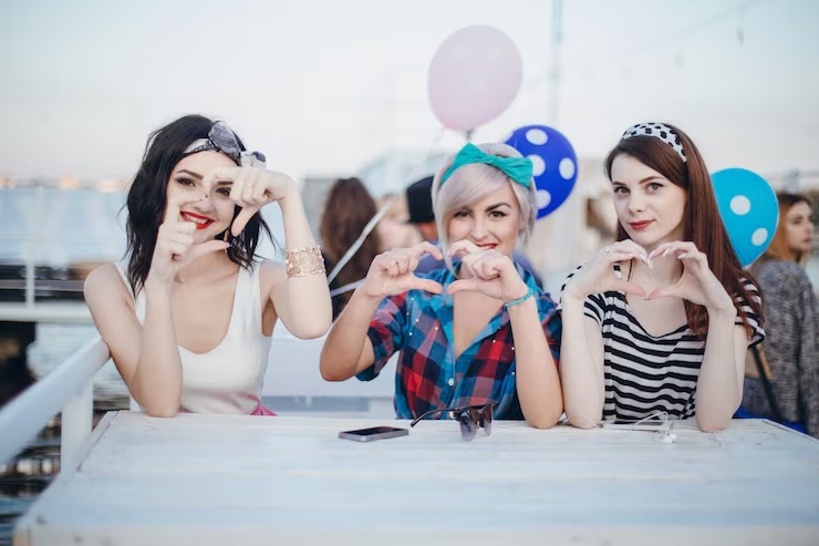 imageye imgi 21 girls sitting table smiling making hearts with hands 1157 907