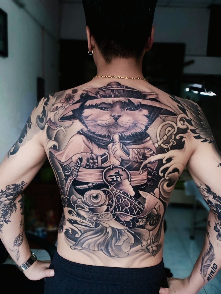 chiêm ngưỡng hình xăm mèo và cá chép đơn sắc Người đàn ông với hình xăm lớn trên lưng, bao gồm hình mèo và cá chép, cùng các chi tiết hoa văn phức tạp.