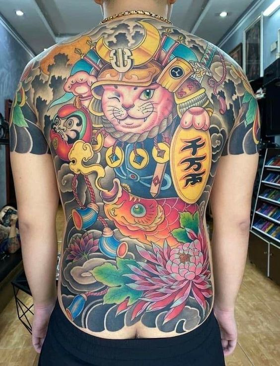 kín lưng hình xăm mèo thần tài đang nheo mắt Hình xăm chi tiết trên lưng với hình mèo, cá chép và hoa sen, mang phong cách nghệ thuật truyền thống.
