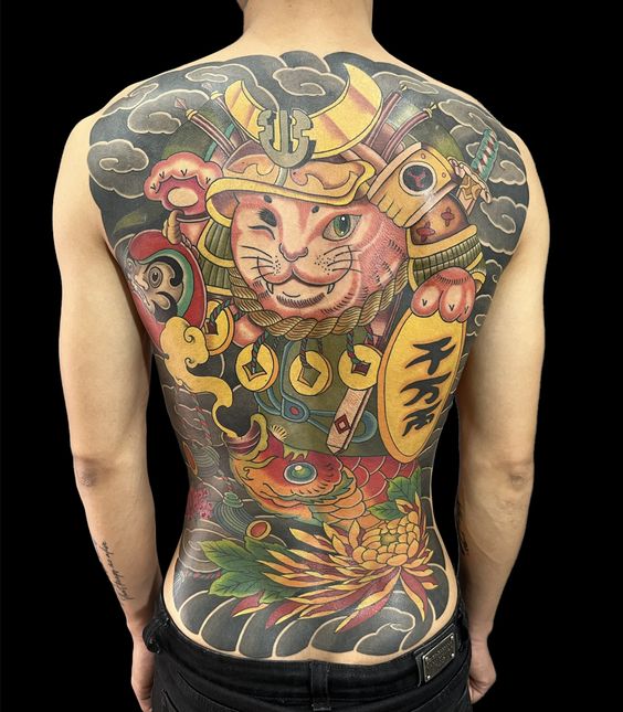 hình xăm samurai mèo thần tài kín lưng cùng họa tiết Nhật Bản Hình xăm màu sắc trên lưng với hình ảnh mèo, cá chép và các chi tiết phong cách Nhật Bản.