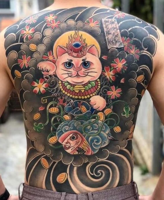 Hình xăm mèo thần tài cưỡi mây, kết hợp búp bê daruma và hoa anh đào Hình xăm trên lưng với hình mèo, hoa và đồng xu, thiết kế phong cách truyền thống và nhiều màu sắc.