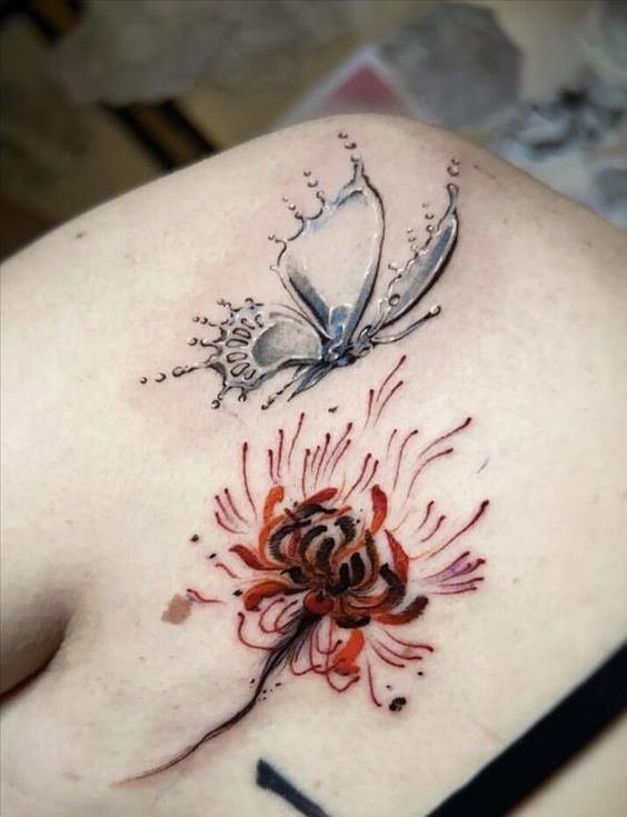 H&igrave;nh xăm tr&ecirc;n vai với thiết kế bướm m&agrave;u x&aacute;m v&agrave; hoa m&agrave;u đỏ cam, n&eacute;t vẽ tinh tế v&agrave; sinh động.