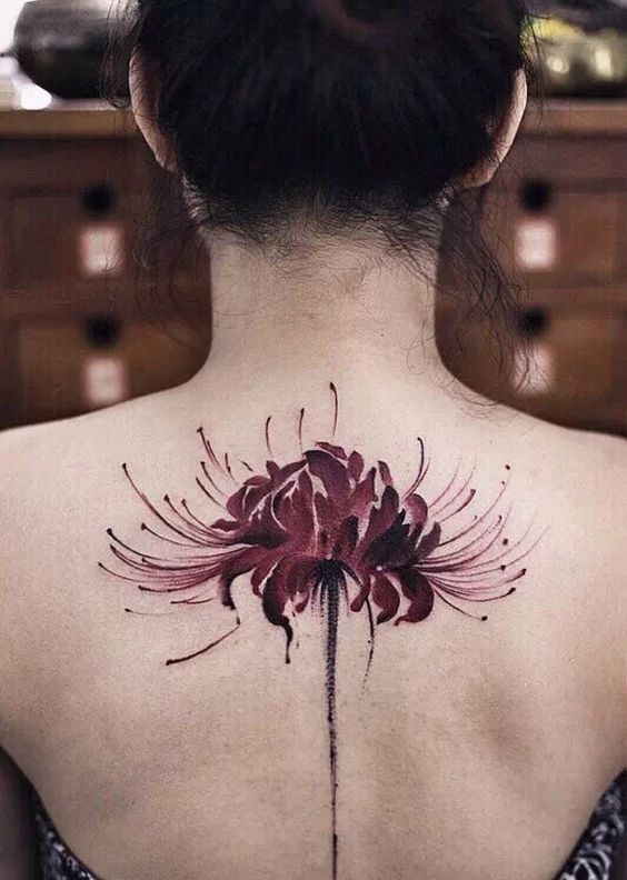 H&igrave;nh xăm hoa m&agrave;u đỏ tr&ecirc;n lưng người, với họa tiết chi tiết v&agrave; phức tạp, nổi bật tr&ecirc;n nền da.