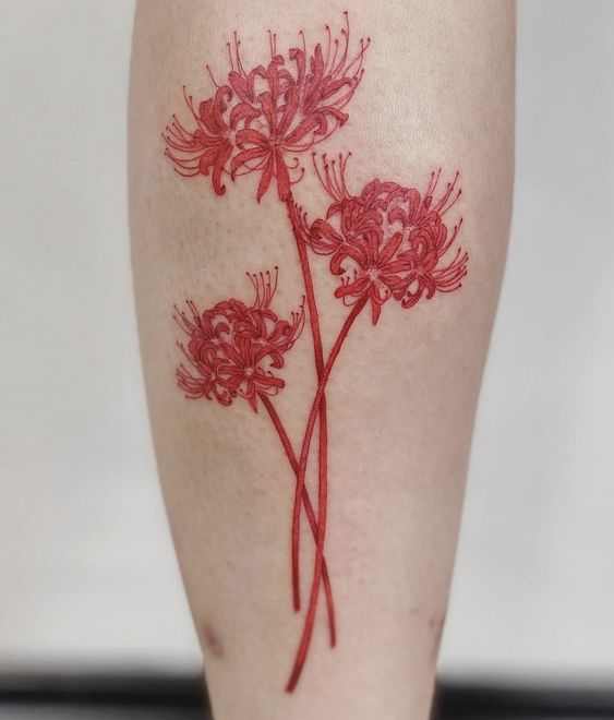 H&igrave;nh xăm hoa m&agrave;u đỏ tr&ecirc;n da với ba b&ocirc;ng hoa ly đang nở, được thiết kế tinh tế v&agrave; tỉ mỉ.