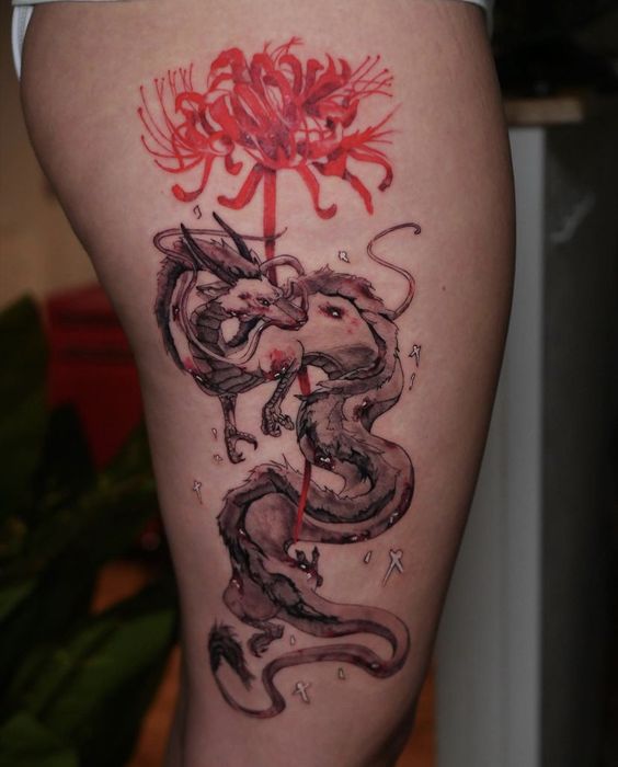 H&igrave;nh xăm tr&ecirc;n đ&ugrave;i với h&igrave;nh rồng v&agrave; hoa m&agrave;u đỏ, n&eacute;t vẽ đậm v&agrave; chi tiết.
