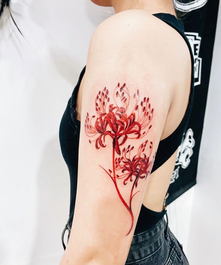H&igrave;nh xăm hoa m&agrave;u đỏ tr&ecirc;n c&aacute;nh tay người, thiết kế cầu kỳ v&agrave; nổi bật tr&ecirc;n nền da.