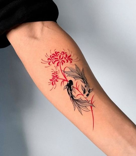 H&igrave;nh xăm tr&ecirc;n c&aacute;nh tay, gồm hai con c&aacute; v&agrave; hoa m&agrave;u đỏ, thiết kế nghệ thuật.