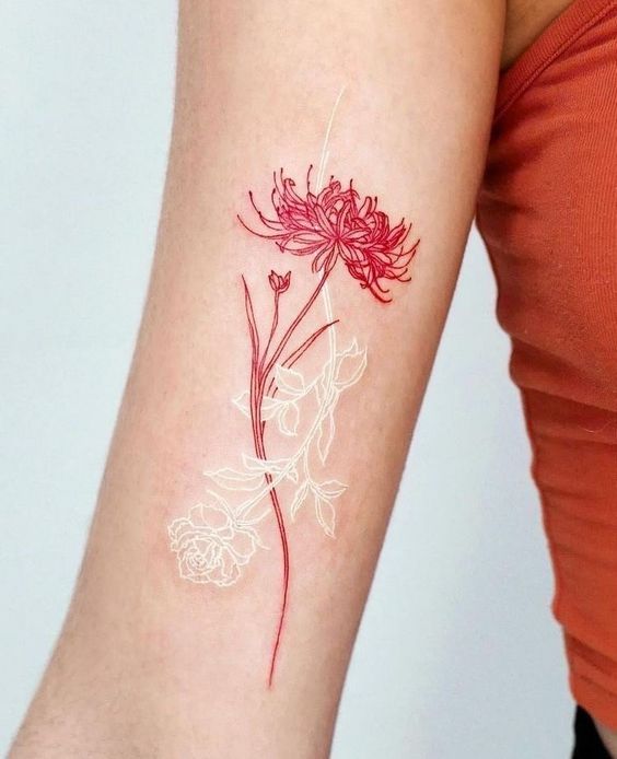 H&igrave;nh xăm hoa đỏ v&agrave; trắng tr&ecirc;n c&aacute;nh tay, người mặc &aacute;o m&agrave;u cam.