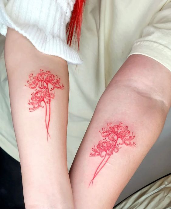 Hai c&aacute;nh tay với h&igrave;nh xăm hoa m&agrave;u đỏ, thiết kế tinh xảo v&agrave; đối xứng.