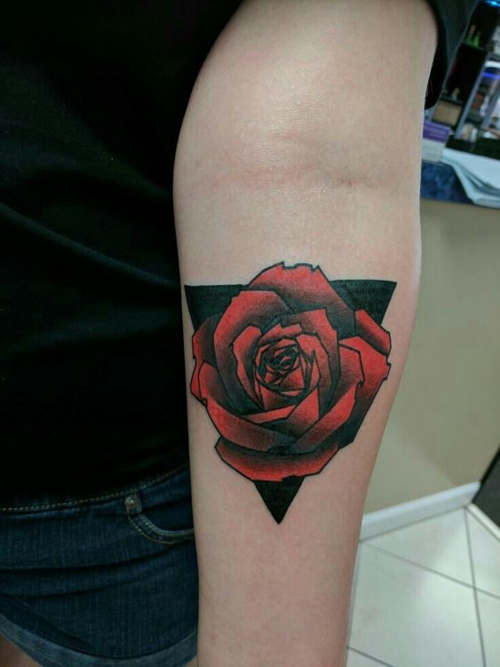 H&igrave;nh xăm hoa hồng đỏ tr&ecirc;n c&aacute;nh tay với nền h&igrave;nh tam gi&aacute;c đen.