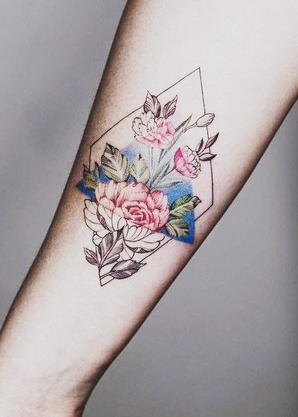 H&igrave;nh xăm hoa m&agrave;u sắc tr&ecirc;n c&aacute;nh tay, với hoa v&agrave; l&aacute; trong khung h&igrave;nh học.