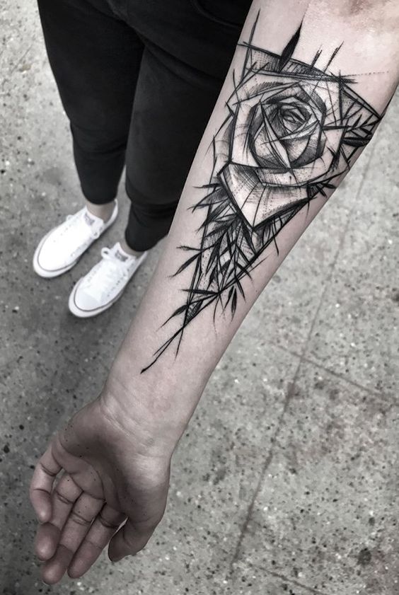 C&aacute;nh tay với h&igrave;nh xăm hoa hồng c&aacute;ch điệu, ống quần v&agrave; gi&agrave;y thể thao m&agrave;u trắng tr&ecirc;n nền gạch x&aacute;m.