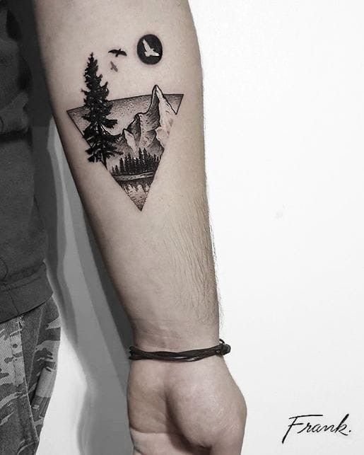 H&igrave;nh xăm tr&ecirc;n c&aacute;nh tay với phong cảnh n&uacute;i non, c&acirc;y cối v&agrave; chim bay, tạo h&igrave;nh tam gi&aacute;c.