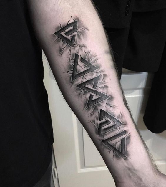 H&igrave;nh xăm tr&ecirc;n c&aacute;nh tay với c&aacute;c k&yacute; tự h&igrave;nh học đen, c&oacute; hiệu ứng 3D v&agrave; vết nứt xung quanh.