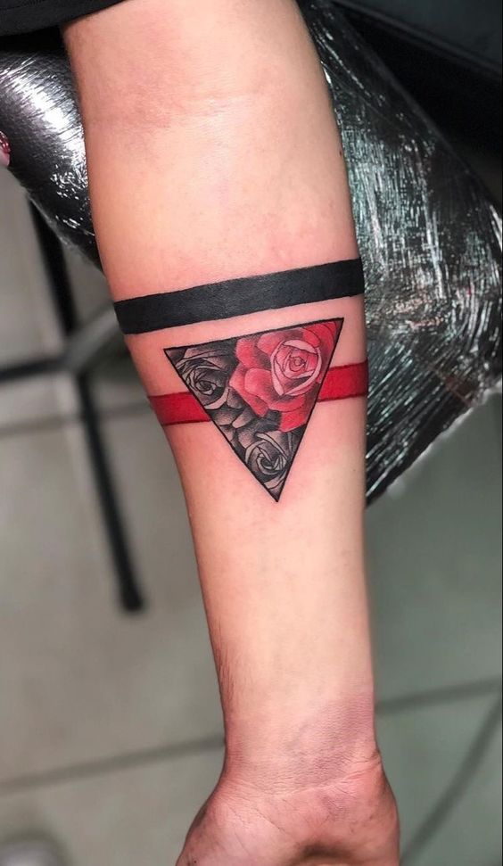 H&igrave;nh xăm c&aacute;nh tay với hoa hồng trong tam gi&aacute;c, k&egrave;m hai dải m&agrave;u đen v&agrave; đỏ ngang.