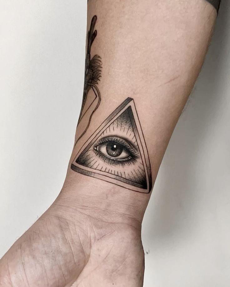 H&igrave;nh xăm tr&ecirc;n c&aacute;nh tay với h&igrave;nh con mắt b&ecirc;n trong tam gi&aacute;c, thiết kế chi tiết v&agrave; sắc n&eacute;t.