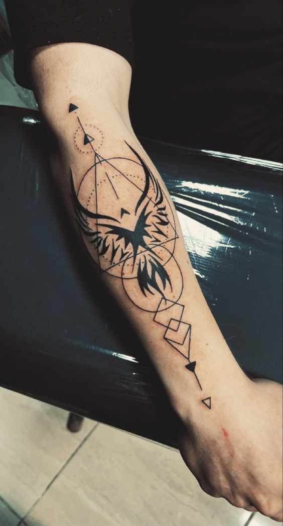 H&igrave;nh xăm h&igrave;nh học tr&ecirc;n c&aacute;nh tay với thiết kế chim phượng ho&agrave;ng v&agrave; c&aacute;c biểu tượng h&igrave;nh học đối xứng.