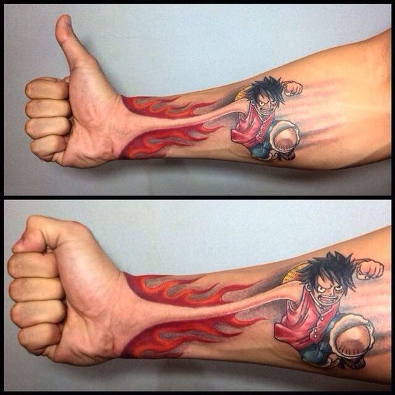 tư thế one piece chuẩn bị chiến đấu Cánh tay có hình xăm nhân vật hoạt hình và lửa, bàn tay làm ký hiệu giơ ngón cái và đấm.