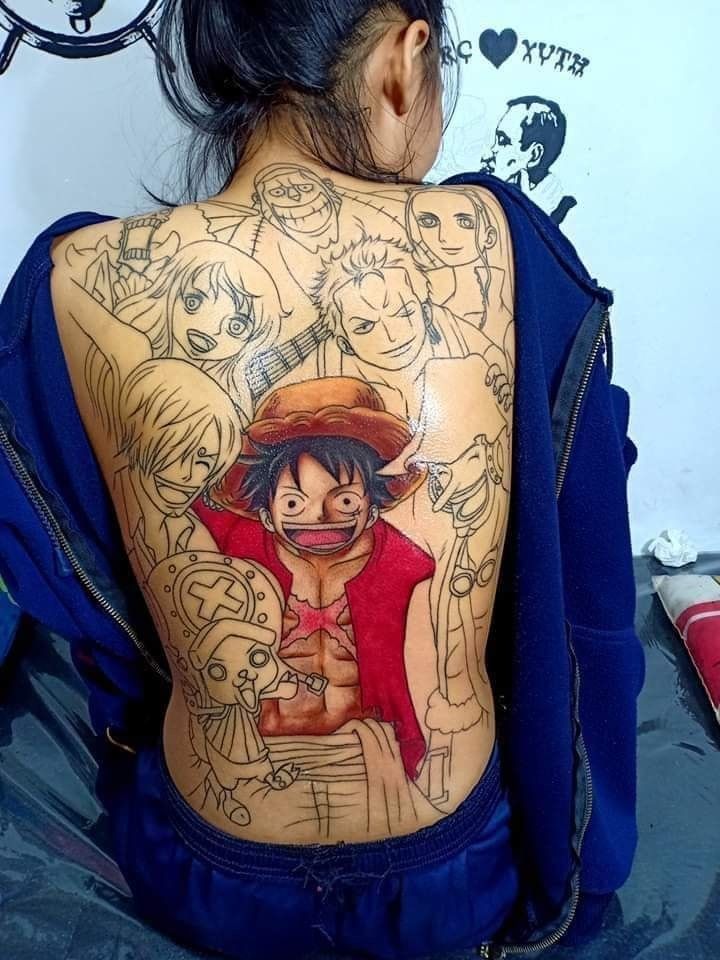 luffy và những người anh em Người với hình xăm trên lưng gồm các nhân vật hoạt hình, một nhân vật có áo đỏ nổi bật ở trung tâm.
