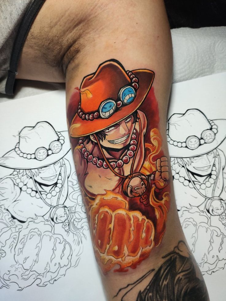 kẻ phản diện one piece máu lửa Hình xăm nhân vật hoạt hình đội mũ, đeo vòng cổ, với nắm đấm lửa, bên cạnh là bản phác thảo đen trắng.