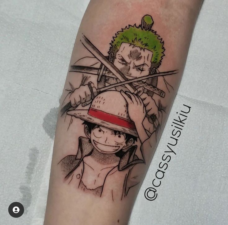 Hình xăm Luffy và Zoro rất đẹp Hình xăm trên tay với hai nhân vật hoạt hình, một người đội mũ rơm và một người cầm kiếm, phong cách anime.