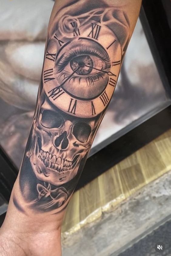 Hình xăm trên cánh tay với thiết kế đầu lâu, đồng hồ La Mã và con mắt ở trung tâm.