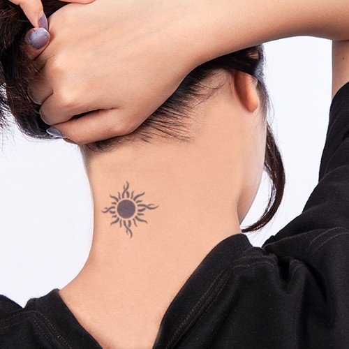 Người với h&igrave;nh xăm mặt trời ở sau g&aacute;y, tay đang v&eacute;n t&oacute;c l&ecirc;n, mặc &aacute;o đen.