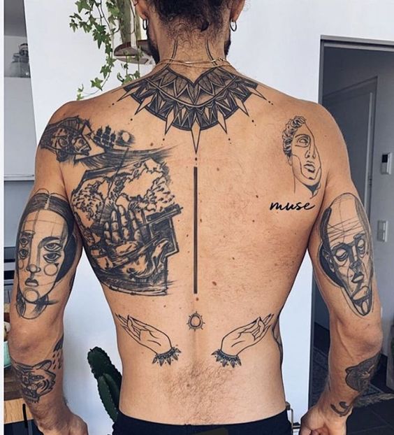 Người đ&agrave;n &ocirc;ng đứng quay lưng, tr&ecirc;n lưng v&agrave; tay c&oacute; nhiều h&igrave;nh xăm nghệ thuật đa dạng với c&aacute;c chi tiết phức tạp.