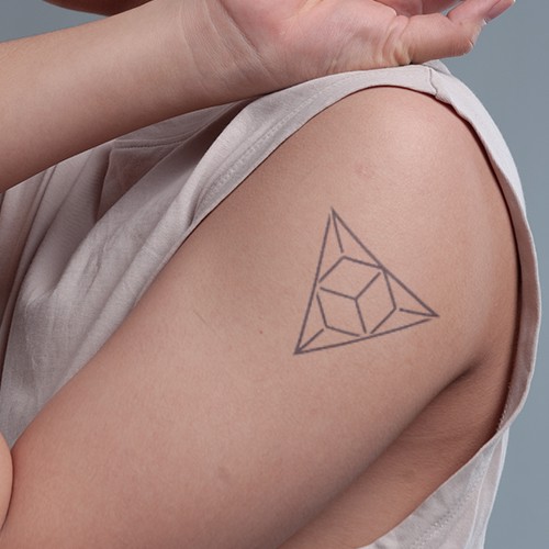 C&aacute;nh tay người với h&igrave;nh xăm h&igrave;nh học c&oacute; h&igrave;nh tam gi&aacute;c v&agrave; khối lập phương.