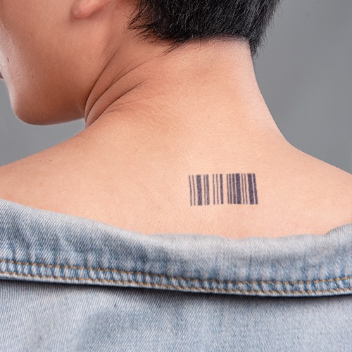 Người mặc &aacute;o kho&aacute;c jean, h&igrave;nh xăm m&atilde; vạch tr&ecirc;n cổ.