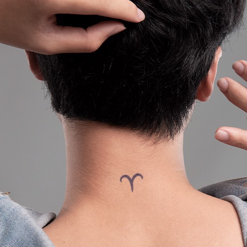 H&igrave;nh xăm biểu tượng tr&ecirc;n g&aacute;y của một người với t&oacute;c ngắn, hai tay chạm v&agrave;o t&oacute;c v&agrave; g&aacute;y.