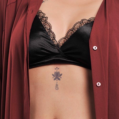 cach-tu-xam-hinh-don-gian-5-min_eaa6d0a3a01c4bb99f15e0ba2e99275a_grande Áo khoác màu nâu đỏ mở hờ, lộ áo lót đen ren và hình xăm nhỏ trên da ở vùng bụng.