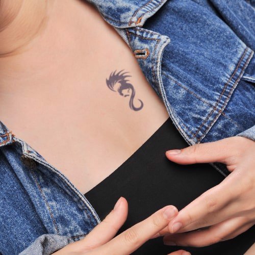 hinh-xam-don-gian-dep-19-min_03f0a22e074445c390fc5748cdaab811_grande Người mặc áo khoác denim, áo đen, có hình xăm nhỏ ở ngực với hình ảnh trừu tượng.