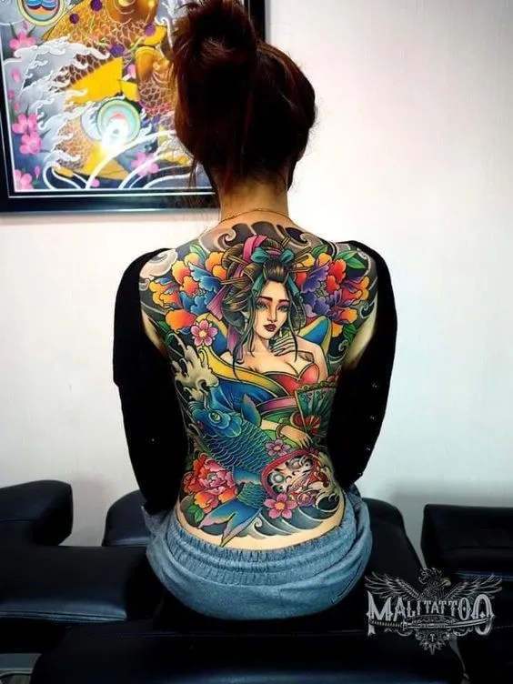 3e43b2bf23308753b868a9c8768c42af Người ngồi lưng quay lại, lưng có hình xăm màu sắc rực rỡ với họa tiết truyền thống và cá.