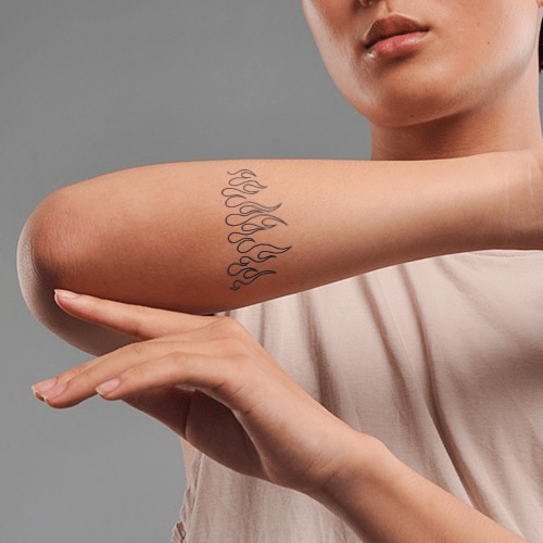 Người mặc áo trắng, cánh tay có hình xăm ngọn lửa, đang giơ lên.