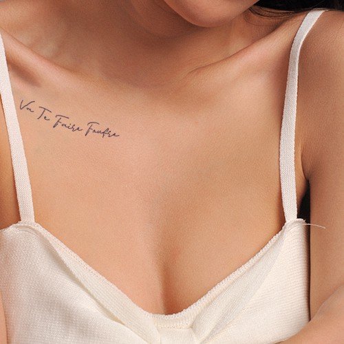 Người mặc áo dây trắng, có hình xăm chữ nhỏ gần xương quai xanh trên nền da.