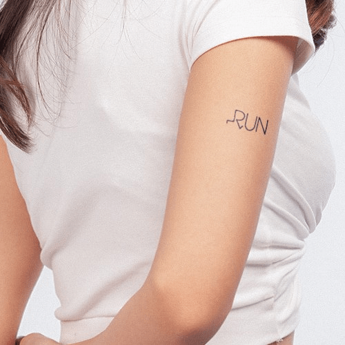 pasted_image_0__6__fab0634d24004b8b95b0a133dd1cc6eb_grande Người mặc áo trắng có hình xăm chữ "RUN" trên cánh tay, tóc dài buông xõa.