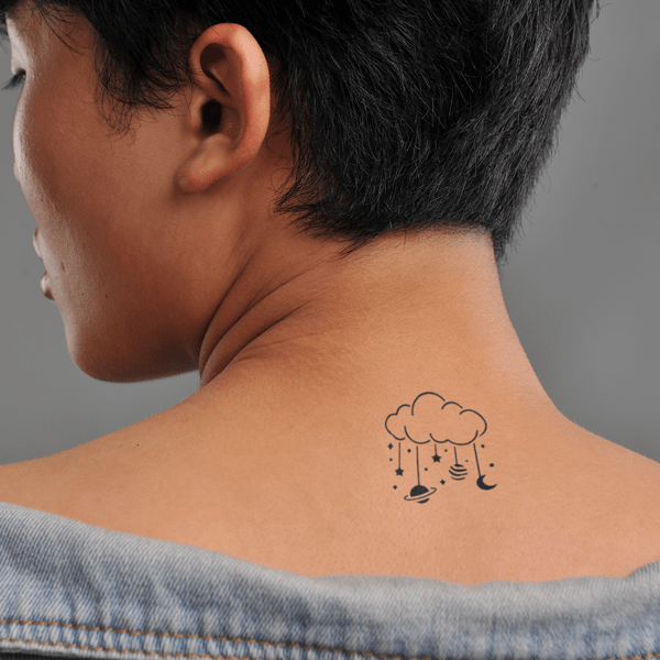 Hình xăm đám mây và các hành tinh nhỏ trên lưng người mặc áo khoác hở vai.